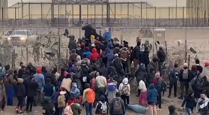 Migrantes intentan derrumbar valla en Ciudad Juárez para entrar a EU.